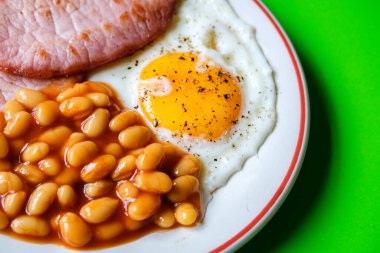 26 Haziran 2025 'te Londra' da domuz pastırmalı kızarmış yumurta ve domates soslu fasulye.