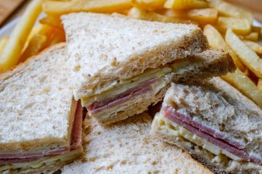 Londra İngiltere, 14 Temmuz 2025, Ev yapımı jambon ve dilimlenmiş kahverengi ekmekli sandviç veya patates kızartması