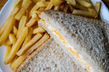 Londra İngiltere, 14 Temmuz 2025, taze yapılmış lezzetli peynirli ve soğanlı sandviç ve patates kızartması.