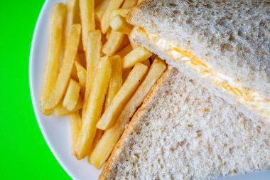 Londra İngiltere, 14 Temmuz 2025, taze yapılmış lezzetli peynirli ve soğanlı sandviç ve patates kızartması.