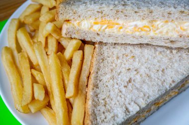 Londra İngiltere, 14 Temmuz 2025, taze yapılmış lezzetli peynirli ve soğanlı sandviç ve patates kızartması.