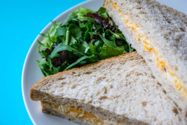 Londra İngiltere, 14 Temmuz 2025, Taze yapılmış Lezzetli Peynir ve Yeşil Salata Yapraklı Soğanlı Sandviç