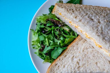 Londra İngiltere, 14 Temmuz 2025, Taze yapılmış Lezzetli Peynir ve Yeşil Salata Yapraklı Soğanlı Sandviç