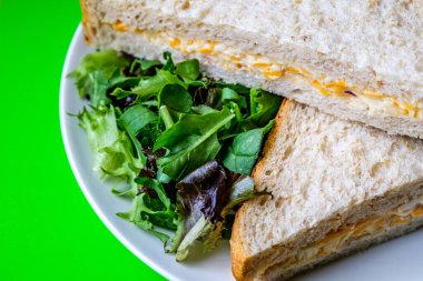 Londra İngiltere, 14 Temmuz 2025, Taze yapılmış Lezzetli Peynir ve Yeşil Salata Yapraklı Soğanlı Sandviç