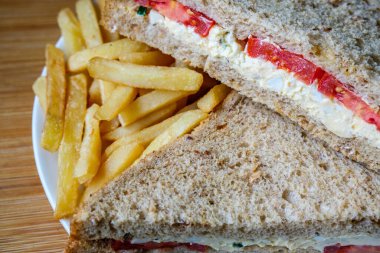 Londra İngiltere, 14 Temmuz 2025, taze yumurta ve salata kremalı domatesli sandviç ve patates kızartması.