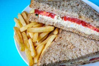 Londra İngiltere, 14 Temmuz 2025, taze yumurta ve salata kremalı domatesli sandviç ve patates kızartması.