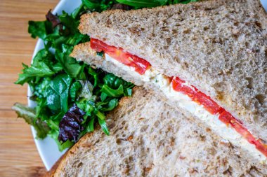 Londra İngiltere, 14 Temmuz 2025, taze yumurta ve salata kremalı domatesli sandviç ve yeşil salata yapraklı.