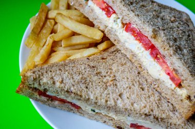 Londra İngiltere, 14 Temmuz 2025, taze yumurta ve salata kremalı domatesli sandviç ve patates kızartması.