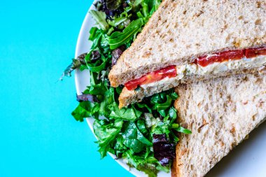 Londra İngiltere, 14 Temmuz 2025, taze yumurta ve salata kremalı domatesli sandviç ve yeşil salata yapraklı.