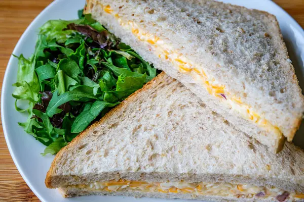 Londra İngiltere, 14 Temmuz 2025, Taze yapılmış Lezzetli Peynir ve Yeşil Salata Yapraklı Soğanlı Sandviç