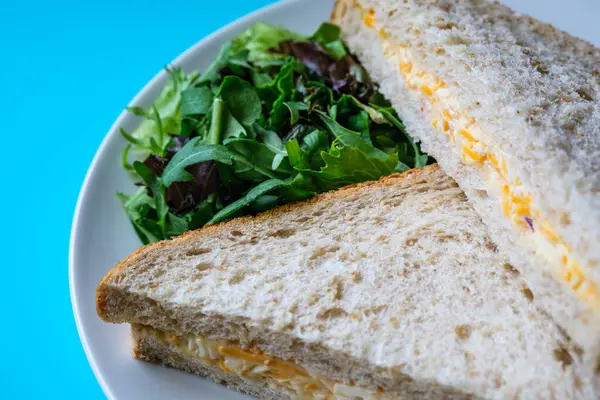 Londra İngiltere, 14 Temmuz 2025, Taze yapılmış Lezzetli Peynir ve Yeşil Salata Yapraklı Soğanlı Sandviç