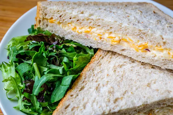 Londra İngiltere, 14 Temmuz 2025, Taze yapılmış Lezzetli Peynir ve Yeşil Salata Yapraklı Soğanlı Sandviç