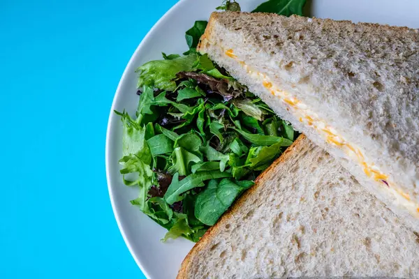 Londra İngiltere, 14 Temmuz 2025, Taze yapılmış Lezzetli Peynir ve Yeşil Salata Yapraklı Soğanlı Sandviç