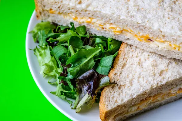 Londra İngiltere, 14 Temmuz 2025, Taze yapılmış Lezzetli Peynir ve Yeşil Salata Yapraklı Soğanlı Sandviç