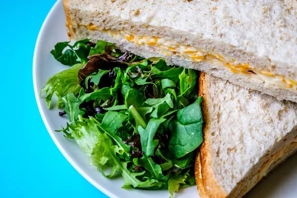 Londra İngiltere, 14 Temmuz 2025, Taze yapılmış Lezzetli Peynir ve Yeşil Salata Yapraklı Soğanlı Sandviç