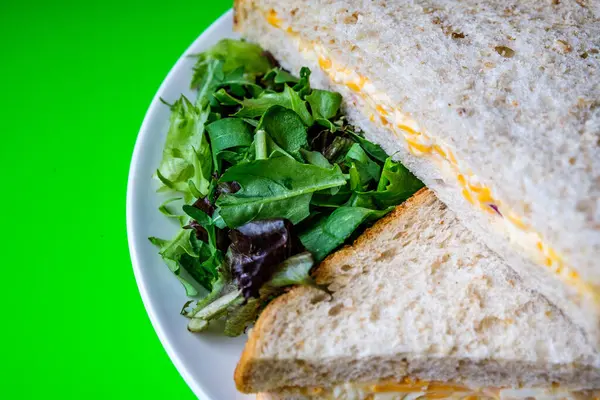 Londra İngiltere, 14 Temmuz 2025, Taze yapılmış Lezzetli Peynir ve Yeşil Salata Yapraklı Soğanlı Sandviç