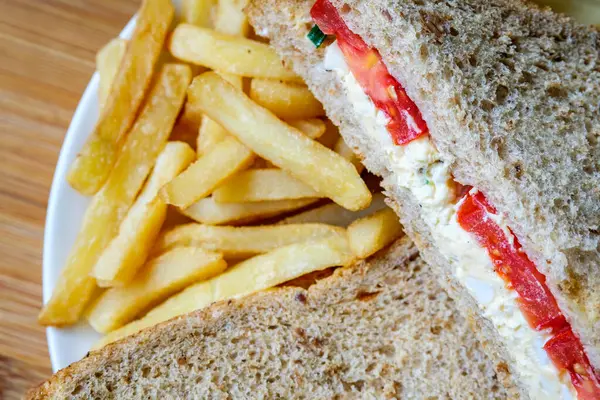 Londra İngiltere, 14 Temmuz 2025, taze yumurta ve salata kremalı domatesli sandviç ve patates kızartması.