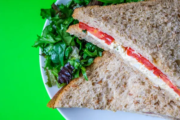 Londra İngiltere, 14 Temmuz 2025, taze yumurta ve salata kremalı domatesli sandviç ve yeşil salata yapraklı.