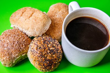 Londra İngiltere, 15 Temmuz 2025, Fırında pişmiş Mini Ekmek Ekmekleri ve bir kupa siyah kahve.