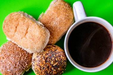 Londra İngiltere, 15 Temmuz 2025, Fırında pişmiş Mini Ekmek Ekmekleri ve bir kupa siyah kahve.