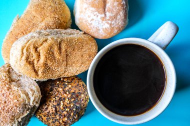 Londra İngiltere, 15 Temmuz 2025, Fırında pişmiş Mini Ekmek Ekmekleri ve bir kupa siyah kahve.