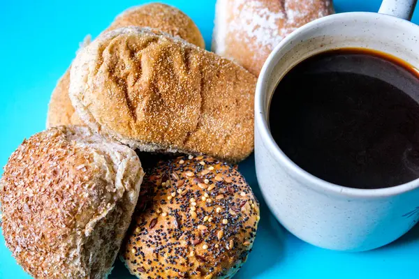 Londra İngiltere, 15 Temmuz 2025, Fırında pişmiş Mini Ekmek Ekmekleri ve bir kupa siyah kahve.