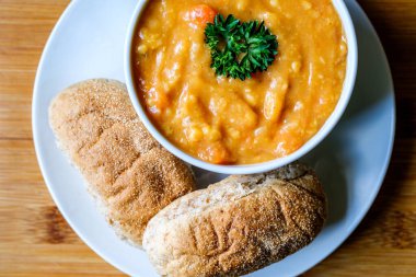 Londra İngiltere, 16 Temmuz 2025, Bir kase maydanozlu mercimek çorbası. Kahverengi denizaltı Rolls Royce ile servis ediliyor.