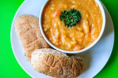 Londra İngiltere, 16 Temmuz 2025, Bir kase maydanozlu mercimek çorbası. Kahverengi denizaltı Rolls Royce ile servis ediliyor.