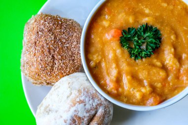 Londra İngiltere, 16 Temmuz 2025, Bir kase sıcak mercimek çorbası Maydanozlu ekmek rulosu