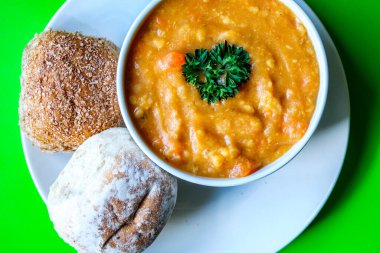 Londra İngiltere, 16 Temmuz 2025, Bir kase sıcak mercimek çorbası Maydanozlu ekmek rulosu