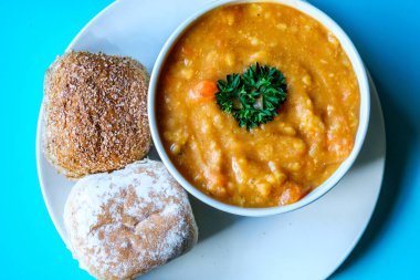 Londra İngiltere, 16 Temmuz 2025, Bir kase sıcak mercimek çorbası Maydanozlu ekmek rulosu