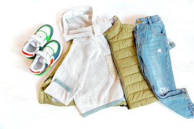 Vest,jumper and jeans pants with sneakers. Set of baby children's clothes,clothing and accessories for spring, autumn or winter on white background. Fashion kids outfit. Flat lay, top view, overhead.