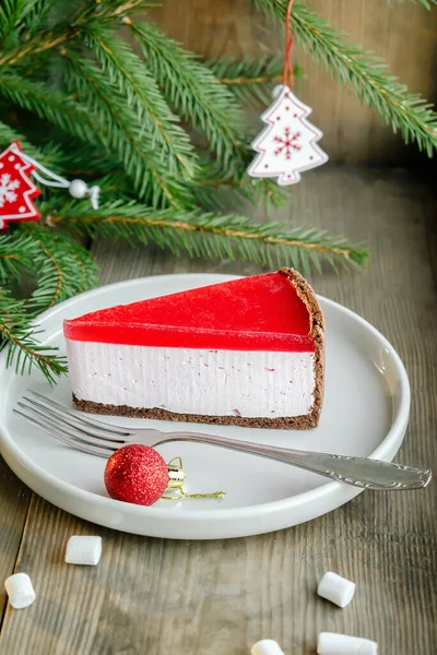 美味的甜经典芝士蛋糕纽约片与五颜六色的红樱桃 草莓果冻顶部 圣诞新年装饰品 冷杉分枝背景 甜点假日食品 — 图库照片