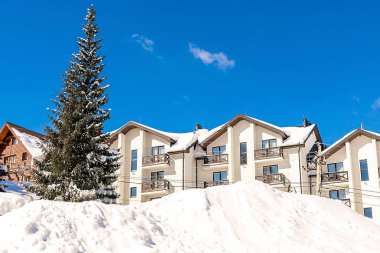 Lüks otel, ev, kışlık orman dağlarında karla kaplı malikane, yeşil yüksek çam ağaçları, doğa. Sakin bir kırsal bölge. Ev adresi, kozalaklı ağaçlarda kayak merkezi. Tatil kavramı