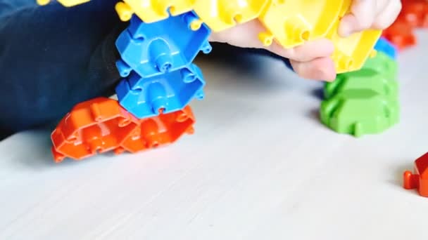 小さな子供の男の子はモザイク建築で遊んでいます 赤ちゃんの手はプラスチックブロックの数字を構築します 子供の論理学 優れた運動能力開発 幼稚園 — ストック動画