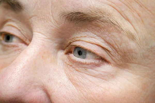 Portrait of wrinkled face of elderly mature older middle aged woman, close up of beautiful female eyes with dry skin.cosmetology care treatment,age skin care beauty cream,medicine,plastic surgery