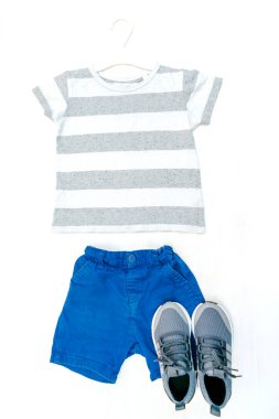 Summer babies blue gray clothes and accessories with t shirt, shorts,sneakers. Modern fashion kids casual outfit.Set of children's clothing for spring. Flat lay, top view,overhead,mockup.