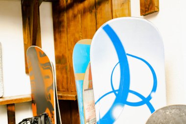 Snowboard 'lar, kayak merkezindeki mevsimlik depo için özel olarak dikilmiş ahşap duvarlara asılan kayaklar. Ekstrem kış sporu malzemeleri evde kullanılıyor.