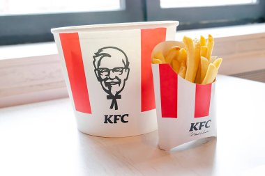 Bucket,chicken nuggets,wings,legs,Fries,coffee menu on tray in KFC restaurant.Fastfood junk food delivery,to go,takeout,take away in kraft paper eco disposable container-Kiev,Ukraine,27 December 2022