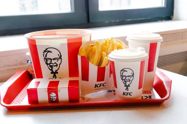 Bucket,chicken nuggets,wings,legs,Fries,coffee menu on tray in KFC restaurant.Fastfood junk food delivery,to go,takeout,take away in kraft paper eco disposable container-Kiev,Ukraine,27 December 2022