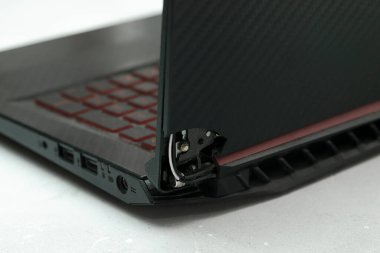 Laptop is broken with arm hinge on the screen,laptop cover,repair loop. cracked plastic laptop split case. computer technology equipment maintenance service concept.