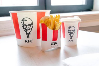 Bucket,chicken nuggets,wings,legs,Fries,coffee menu on tray in KFC restaurant.Fastfood junk food delivery,to go,takeout,take away in kraft paper eco disposable container-Kiev,Ukraine,27 December 2022