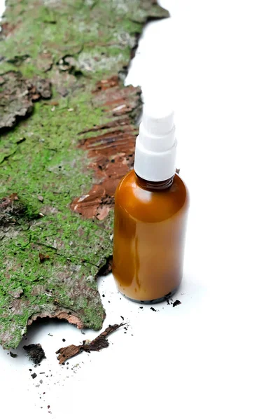 Glass dropper brown bottle with cosmetic oil, cream, essential or serum on bark tree and green moss. Concept of natural organic eco spa cosmetics. Herbal homeopathic products, copy space.