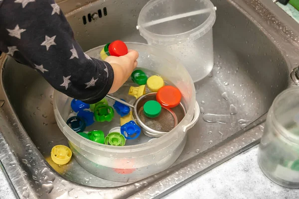 Suyun Içinde Şişe Kapaklarıyla Oynayan Bir Çocuk Mutfak Lavabosu Çocuk — Stok fotoğraf
