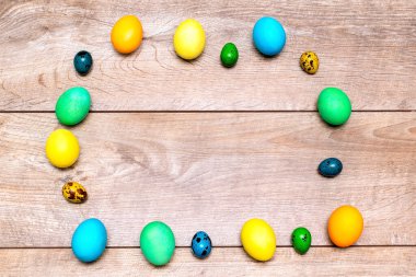Renkli paskalya tavuğu ve bıldırcın yumurtası çerçevesi ahşap kırsal arka plan fotokopi alanı, bahar paskalya modeli konsept, üst görünüm.
