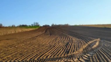 Plowed agricultural field ready for seed sowing, planting crops.Newly ploughed field with furrows. Sunny countryside lanscape.cultivating and make soil tillage, nature countryside rural.