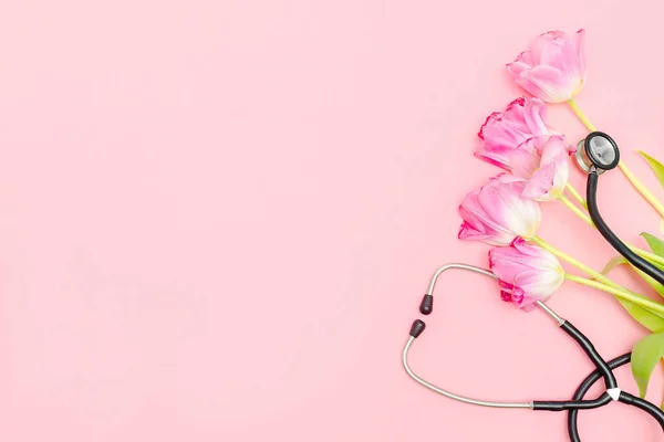 National Doctor\'s or nurse day greeting card with stethoscope, bunch of tulips flowers on pink background. Health medicine Day.Copy space for text.mockup.