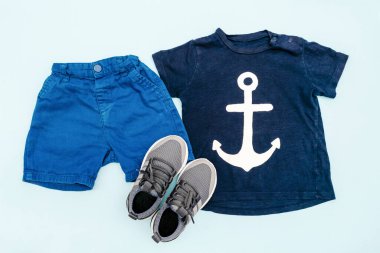 Yaz bebekleri mavi elbiseler ve tişörtlü aksesuarlar, şort, spor ayakkabılar. Modern moda çocuk kıyafetleri. Bahar ya da yaz için çocuk kıyafetleri. Düz yatış, üst görünüm, genel görünüş, model.