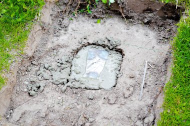Çimento çözeltisi içinde demir yapısı, çamur, yerde beton harç. İnşaat süreci, yenileme, ev temelleri hazırlama.