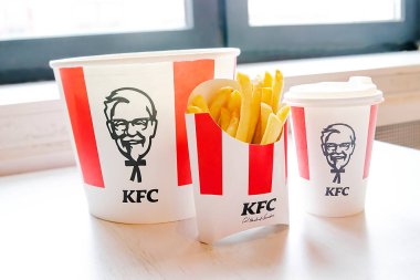 Bucket,chicken nuggets,wings,legs,Fries,coffee menu on tray in KFC restaurant.Fastfood junk food delivery,to go,takeout,take away in kraft paper eco disposable container-Kiev,Ukraine,27 December 2022